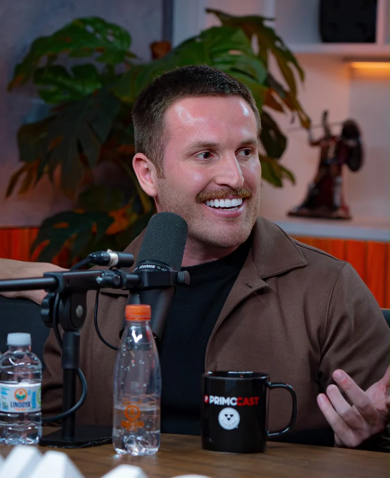 Guilherme Batilani sorrindo em uma conversa no podcast
